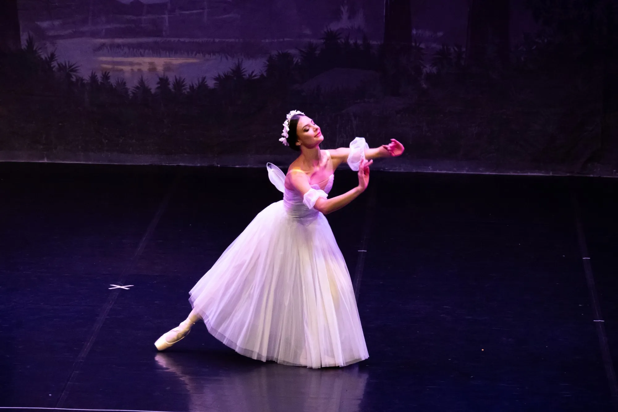 A dancer wearing a flowing white dress and flower crown performs a solo as part of YRBC's 2023 production of Les Sylphides ballet.
